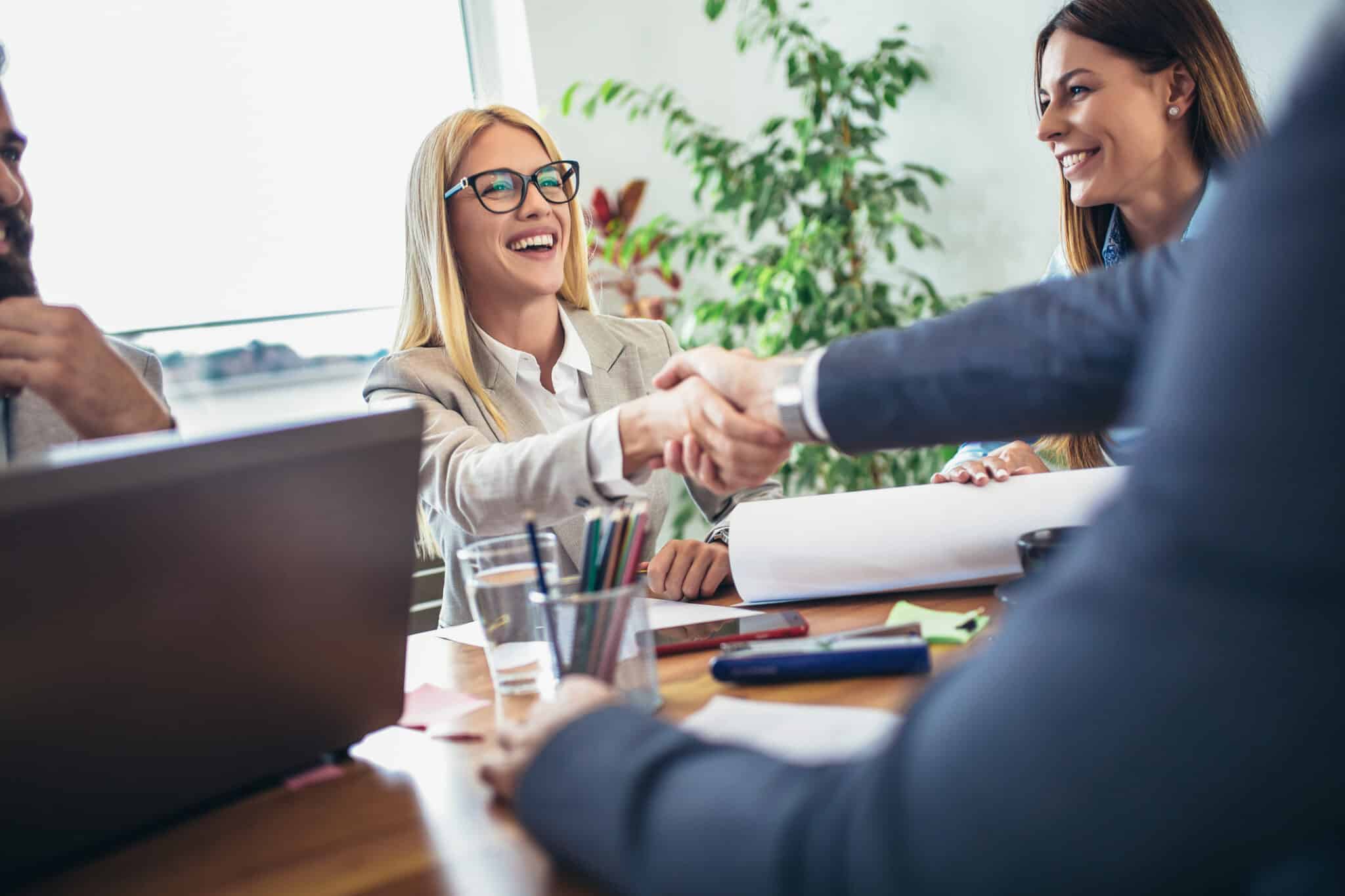 Young business people shaking hands in the office. Finishing successful meeting